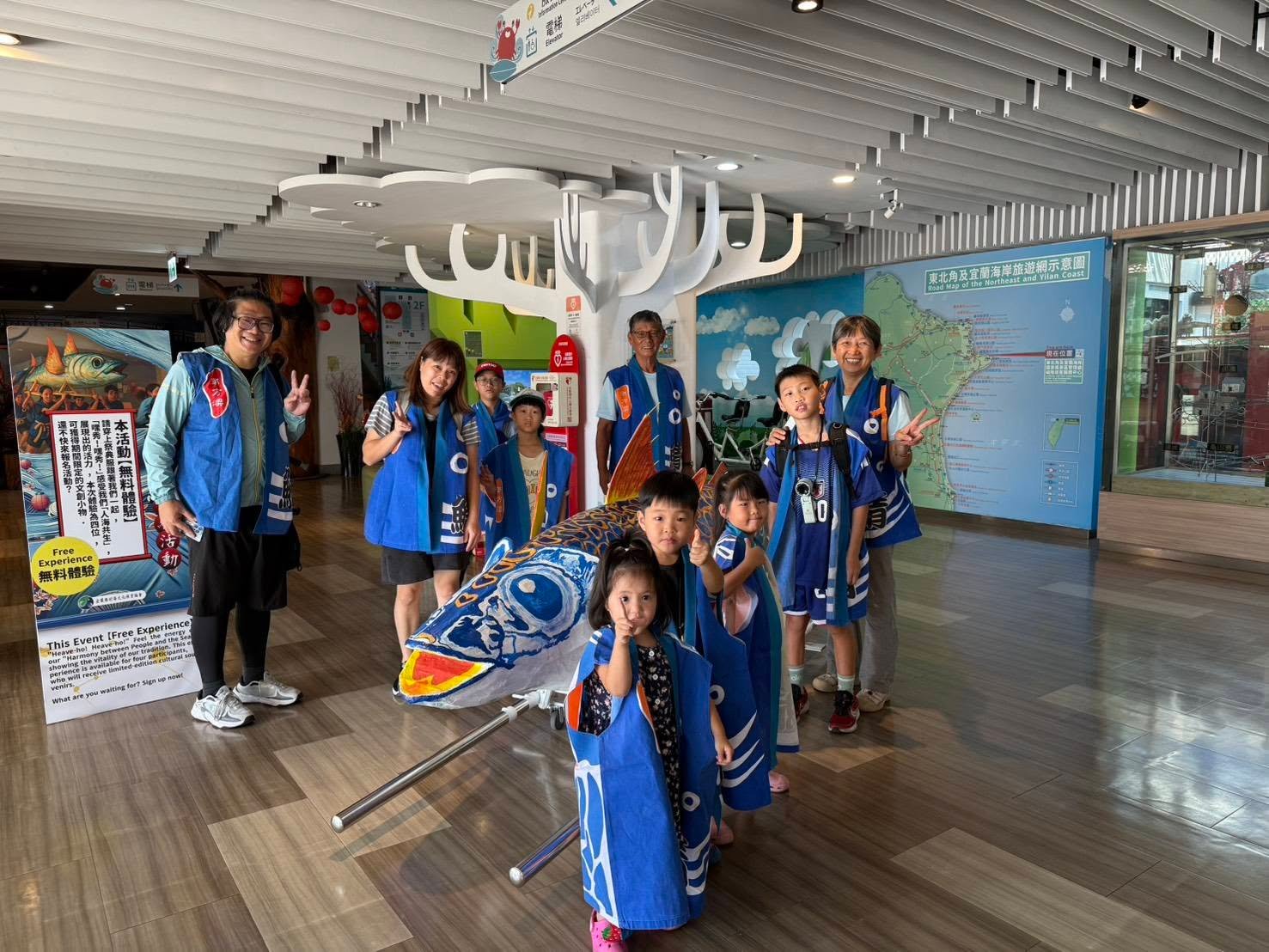 參與者與大鯖魚作品在福隆遊客中心室內展示空間合影